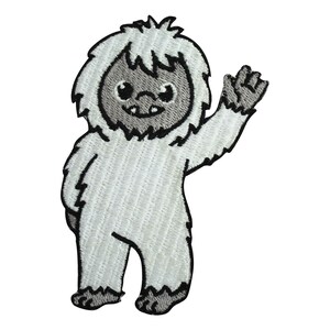 May include: A white embroidered patch of a cartoon yeti waving with a friendly expression.