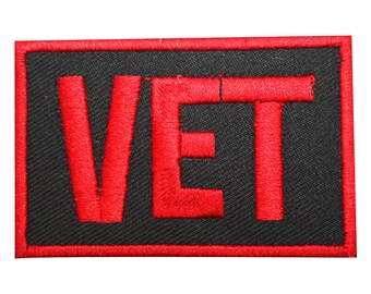 May include: Red embroidered patch with the word "VET" in black outlined letters on a black background.