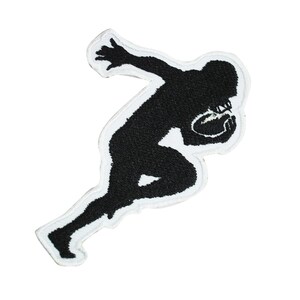 Peut inclure: Silhouette noire d'une personne en position de course, tenant un ballon de football. La silhouette est brodée sur un patch en tissu blanc.