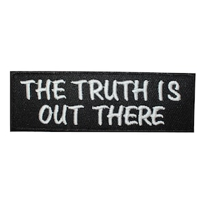 May include: Black embroidered patch with white text that reads "THE TRUTH IS OUT THERE".