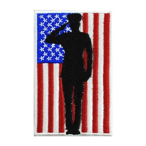 Könnte beinhalten: Ein gestickter Aufnäher mit der Silhouette einer Person, die vor einer amerikanischen Flagge salutiert. Die Flagge ist rot, weiß und blau mit weißen Sternen auf einem blauen Feld.