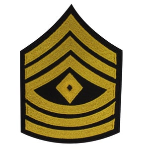 May include: A gold embroidered military rank patch with five gold stripes and a diamond shape in the center.