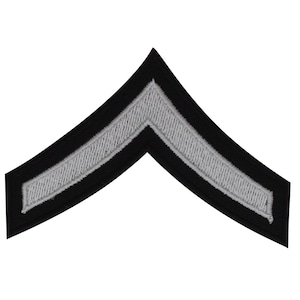 May include: A black and silver chevron patch with a single silver stripe. The patch is commonly used as a military rank insignia.