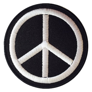 Peut inclure: Un patch circulaire noir avec un symbole de paix blanc brodé.