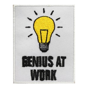 May include: White embroidered patch with a yellow light bulb and the text "Genius at Work" in black.