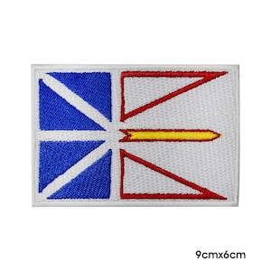 May include: An embroidered patch featuring the flag of Newfoundland and Labrador. The flag is white with a red cross and a yellow diagonal line in the center. The patch is 9 inches by 6 inches.