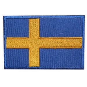 May include: An embroidered patch featuring the flag of Sweden, with a yellow cross on a blue background.