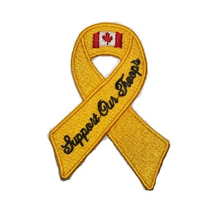 Könnte beinhalten: Gelbes Band mit dem Text "Support Our Troops" und einer kanadischen Flagge in der Mitte.