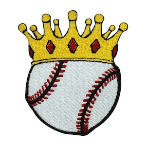 May include: A white baseball with red stitching is topped with a gold crown with red diamond accents. The crown and baseball are embroidered.