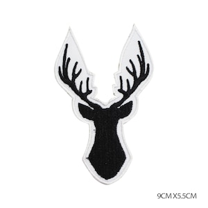 May include: Black embroidered iron-on patch of a deer head with antlers. The patch is 9 cm by 5.5 cm.