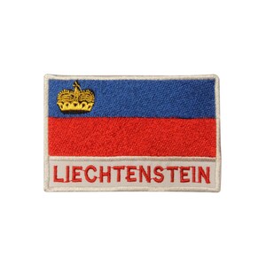 May include: Embroidered patch featuring the flag of Liechtenstein. The flag is blue with a red stripe and a gold crown in the upper left corner. The word "LIECHTENSTEIN" is written in white below the flag.