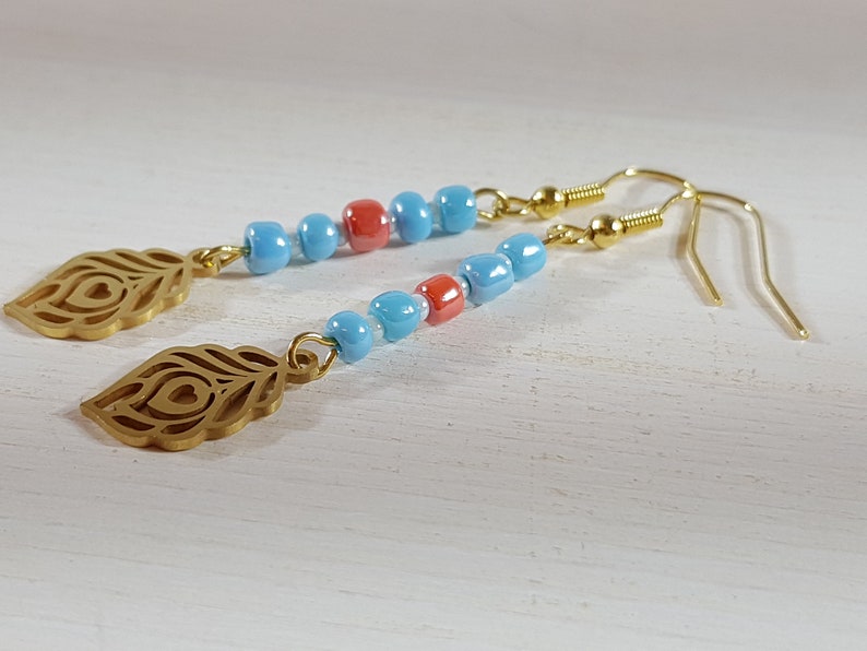 Long feather gold pendant earrings with blue and red glass beads
