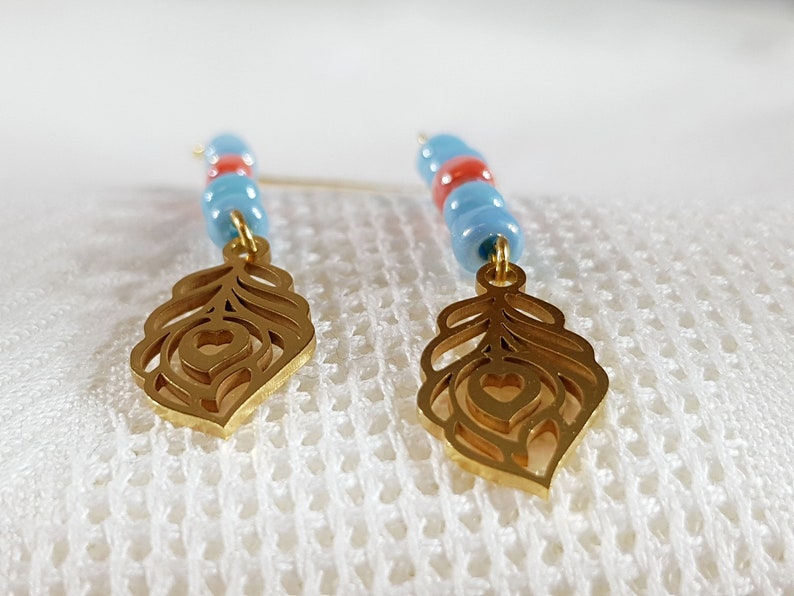 Long feather gold pendant earrings with blue and red glass beads