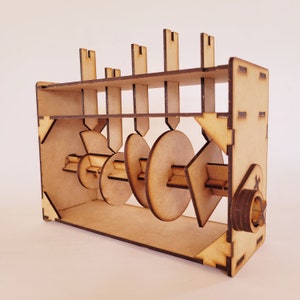 May include: A wooden model of a gear system with multiple gears and a wooden frame. The gears are connected by a metal rod and are designed to rotate.