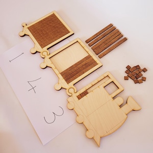 May include: Wooden train puzzle with separate pieces, including a rectangular top, a frame with a section of wooden slats, and a train engine shape. Additional small wooden squares and rectangular pieces are also included. A paper with the numbers 1, 4, and 3 is in the image.