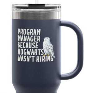 Puede incluir: Vaso térmico azul marino con asa y pajita. El vaso presenta el texto "PROGRAM MANAGER BECAUSE HOGWARTS WASN'T HIRING" y una ilustración de un búho nival.
