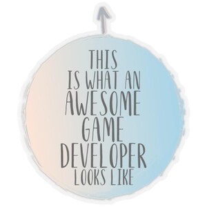 May include: A sticker with a light blue, peach, and white background. The text reads "THIS IS WHAT AN AWESOME GAME DEVELOPER LOOKS LIKE" in a dark gray font. An upward-pointing arrow is at the top.