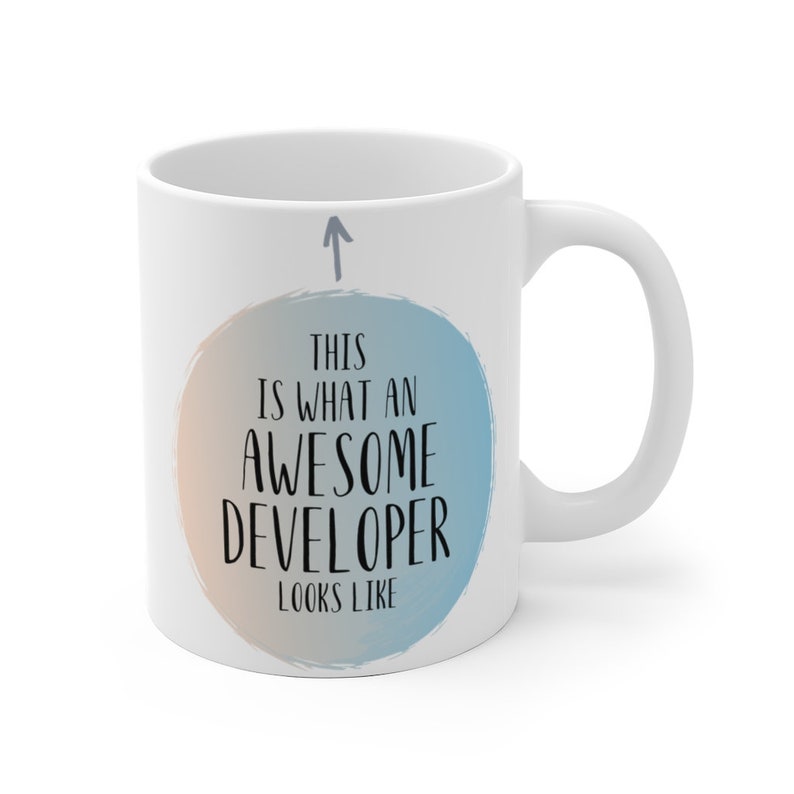 Pode incluir: Caneca de caf&eacute; de cer&acirc;mica branca com um design de aquarela azul e laranja. A caneca tem uma seta apontando para cima e o texto "&Eacute; assim que um desenvolvedor incr&iacute;vel parece".