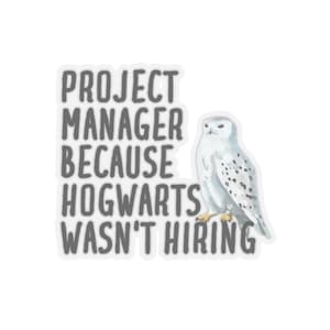 May include: A white sticker with gray text that reads "Project Manager Because Hogwarts Wasn't Hiring". A white snowy owl is to the right of the text.