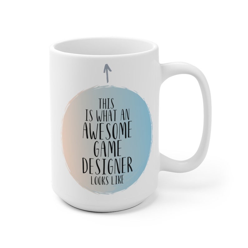 May include: White ceramic coffee mug with a blue and orange watercolor circle design. The text "This is what an awesome game designer looks like" is printed in black on the mug.