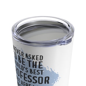 Op de afbeelding: Witte reistumbler van roestvrij staal met een blauw aquarelontwerp en de tekst "Ik heb nooit gevraagd om de beste professor ter wereld te zijn, maar hier ben ik."