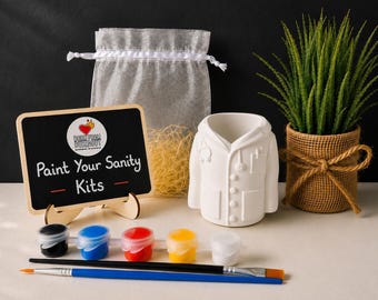 May include: A craft kit featuring a white ceramic doctor coat figurine, a small chalkboard sign with the text Paint Your Sanity Kits, a sheer drawstring bag with filler, five small paint pots in black, blue, red, yellow, and white, and two brushes.