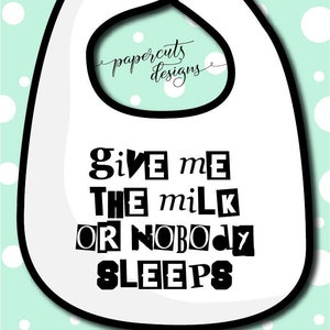 May include: White baby bib with black text that reads "Give me the milk or nobody sleeps".