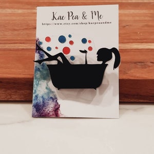 May include: A black silhouette of a person in a bathtub with red and blue bubbles. The image is on a white card with the text "Kae Pea & Me" and a website address.