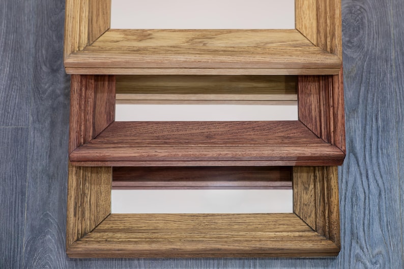 May include: A wooden shelf unit with three shelves. The shelves are made of different types of wood, creating a unique and rustic look.