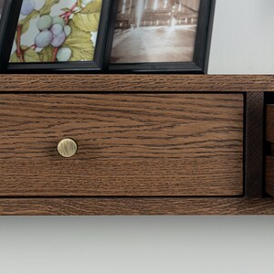 Puede incluir: Una taza de cer&aacute;mica blanca con un asa negra y el texto "But First, Coffee" en negro, con una fuente de estilo manuscrito. La taza est&aacute; sobre una superficie blanca.