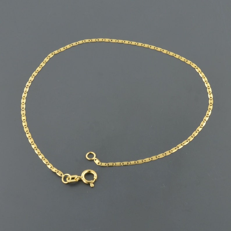 May include: A gold chain anklet with a lobster clasp closure.