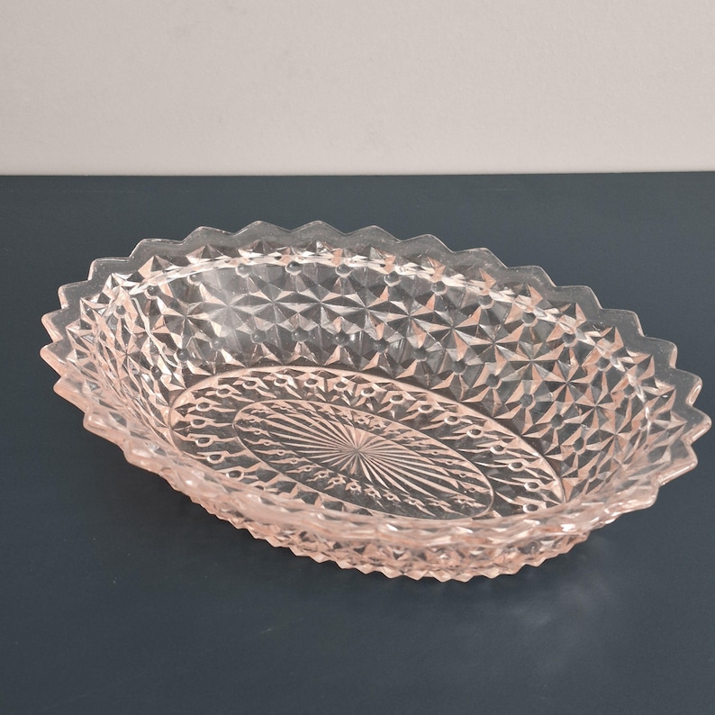 K&ouml;nnte beinhalten: Rosa, ovales Glasgeschirr mit Rautenmuster und gewelltem Rand. Die Mitte des Geschirrs weist ein Sonnenstrahl-Design auf. Ideal zum Servieren oder Dekorieren.