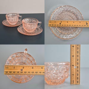 K&ouml;nnte beinhalten: Zwei rosafarbene Teetassen und Untertassen aus Glas mit einem Rautenmuster. Die Untertassen haben einen Durchmesser von ca. 12.7 cm. Die Teetassen sind etwa 7.6 cm hoch. Das Set besteht aus klarem rosa Glas.