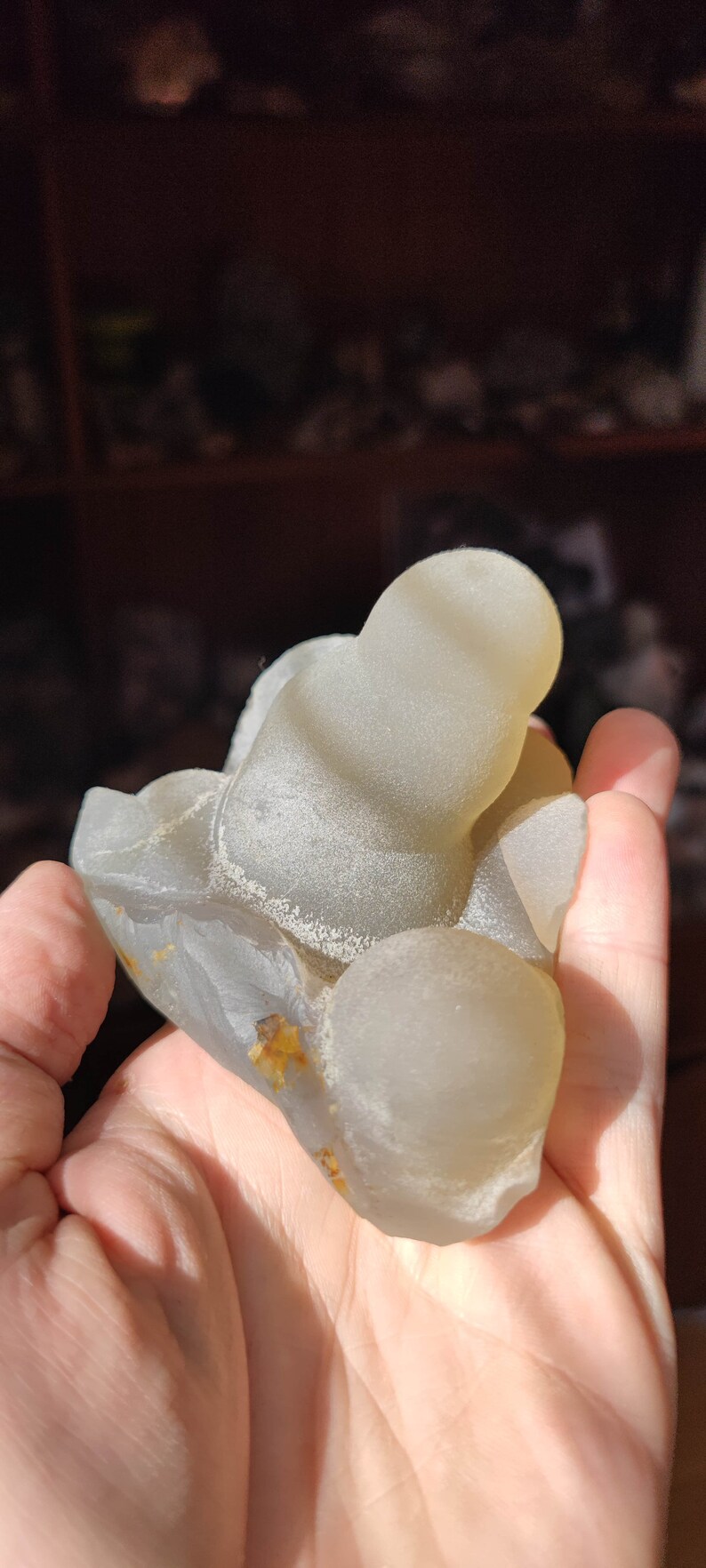 May include: A light gray agate geode with a smooth, rounded surface. The geode has a natural, organic shape and is a beautiful example of a natural crystal formation.