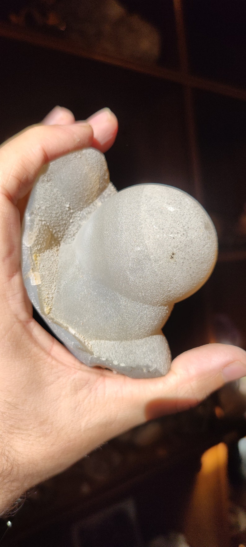 Peut inclure: Une g&eacute;ode blanche de forme irr&eacute;guli&egrave;re avec une surface rugueuse et textur&eacute;e. La g&eacute;ode est partiellement ouverte, r&eacute;v&eacute;lant un int&eacute;rieur cristallin.