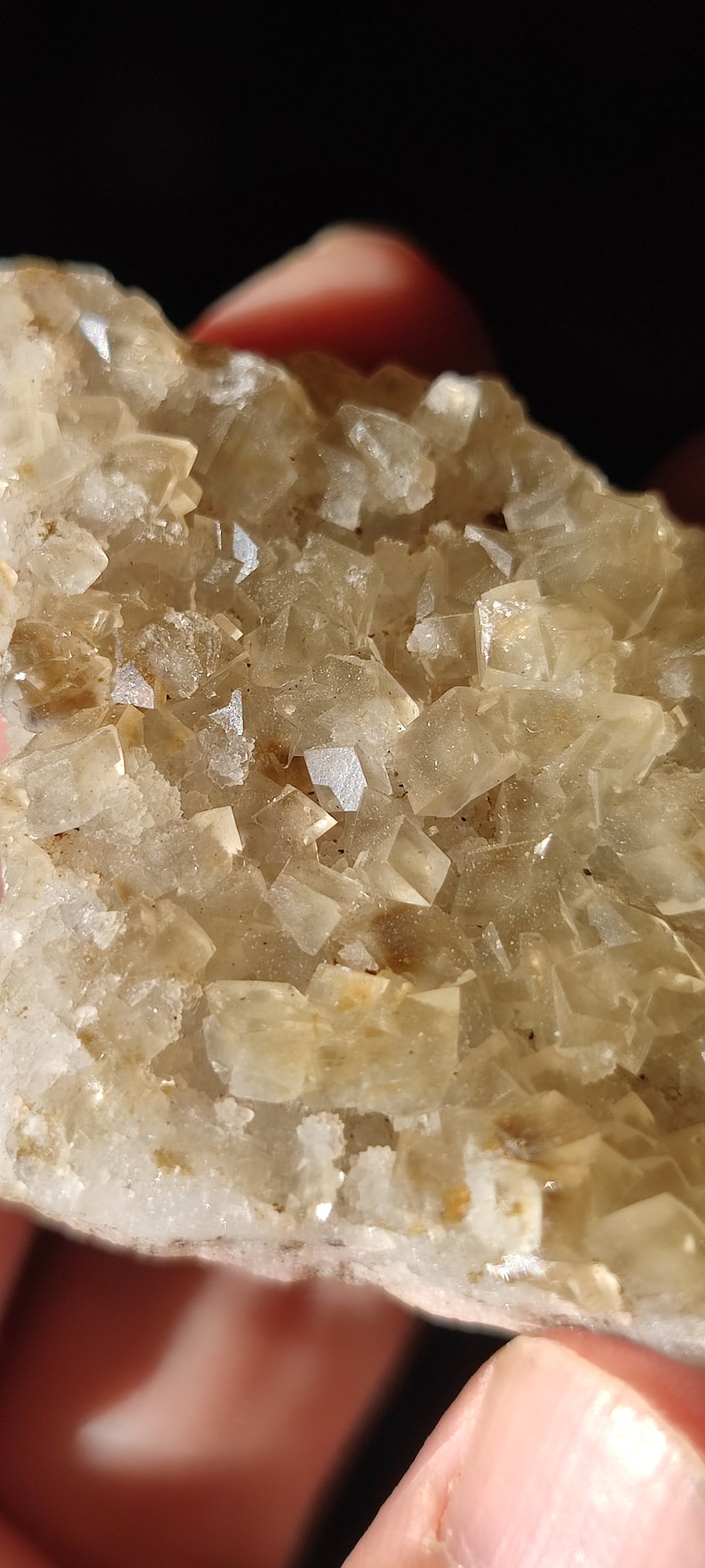 Pu&ograve; includere: Un gruppo di cristalli traslucidi di colore marrone chiaro con una texture ruvida e naturale.