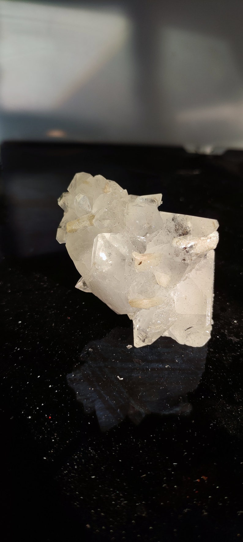 May include: A cluster of clear quartz crystals with a rough, natural texture. The crystals are arranged in a random, organic pattern, creating a unique and interesting display.