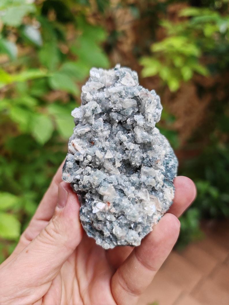 May include: A cluster of light blue and white crystals with a rough, natural texture. The crystals are arranged in a random, organic pattern, creating a unique and interesting piece.