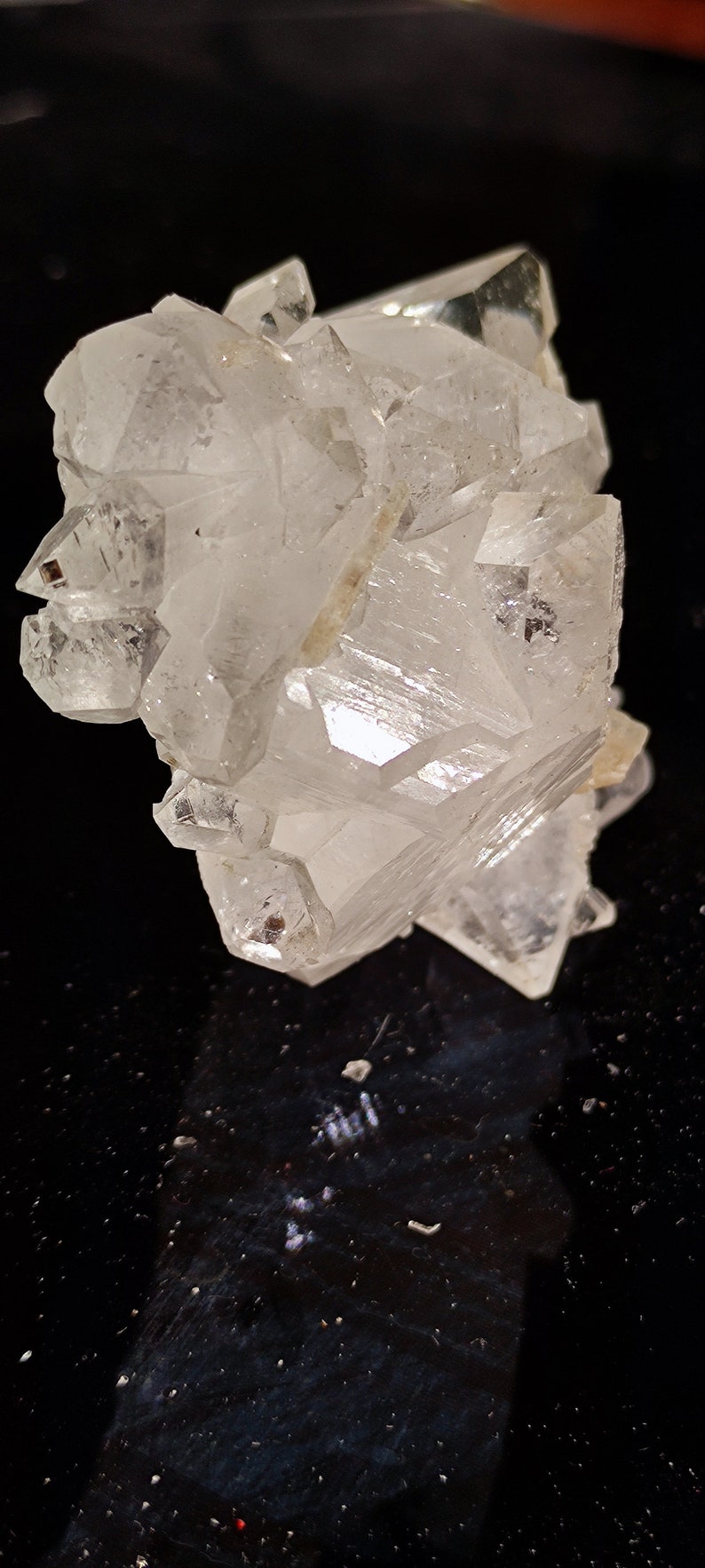 May include: A cluster of clear quartz crystals with a variety of shapes and sizes. The crystals are arranged in a random pattern and have a natural, rough texture.