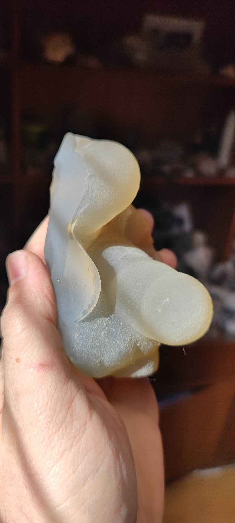 May include: A white agate geode with a smooth, translucent surface. The geode has a unique, organic shape and is a beautiful example of natural beauty.