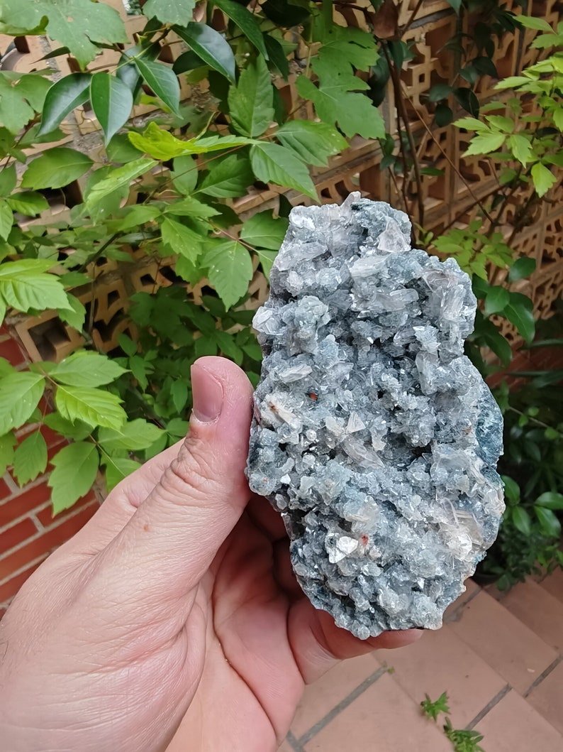 May include: A cluster of green celestite crystals with a white, translucent, crystalline structure. The crystals are clustered together in a rough, natural formation.