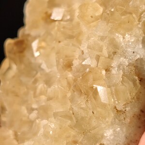 Pu&ograve; includere: Primo piano di un ammasso di cristalli marroni chiari con una superficie ruvida e testurizzata.