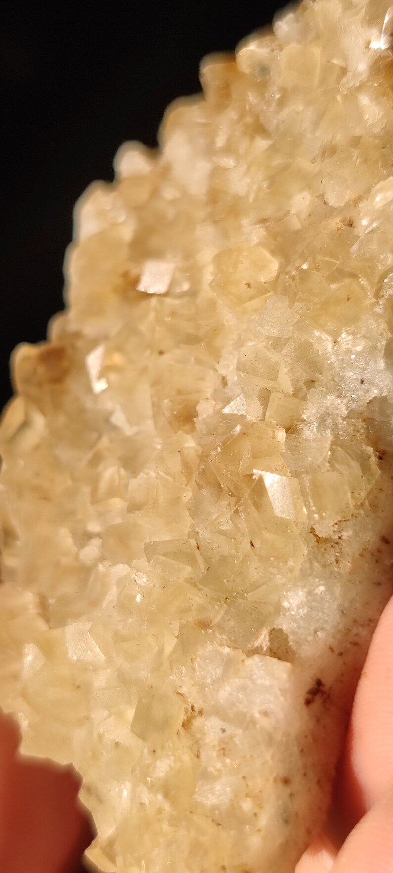 Pu&ograve; includere: Primo piano di un ammasso di cristalli marroni chiari con una superficie ruvida e testurizzata.