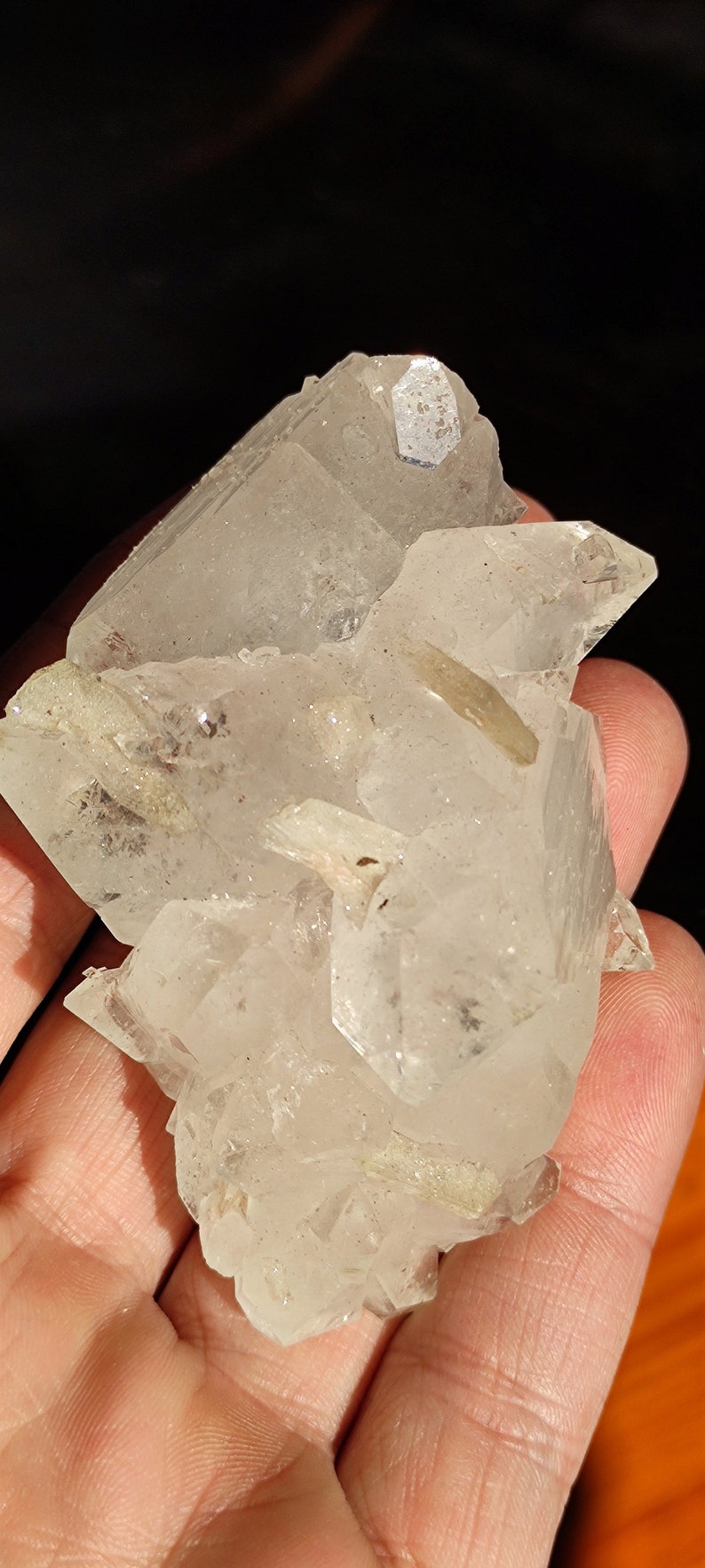 May include: A cluster of clear quartz crystals with a slightly cloudy appearance. The crystals are clustered together in a natural formation.