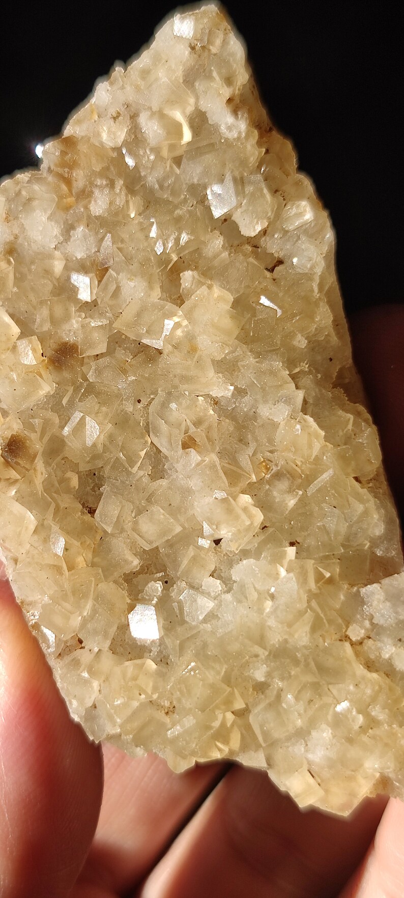 Pu&ograve; includere: Un ammasso di cristalli traslucidi di colore marrone chiaro con una texture ruvida e naturale. I cristalli sono raggruppati in una formazione densa, creando un pezzo visivamente interessante e unico.