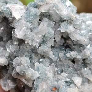 May include: A cluster of clear, glassy crystals with a blue-green tint. The crystals are arranged in a random, organic pattern, creating a visually interesting and unique piece.