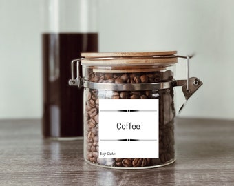 May include: A glass jar with a bamboo lid filled with coffee beans. The jar has a white label with the word "Coffee" and the text "Exp Date:".