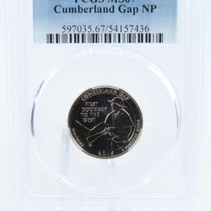 May include: A 2016-P Cumberland Gap National Park quarter coin, encapsulated in a protective case. The coin features an image of a person with a rifle and the text "First Doorway to the West". The coin is graded PCGS MS67.