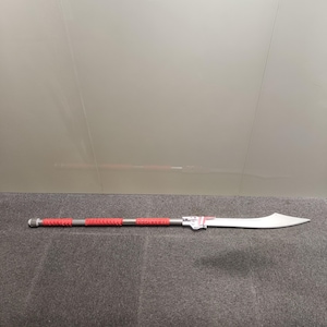 May include: A silver-colored sword with a red and black handle. The sword is about 4 feet long and has a curved blade.
