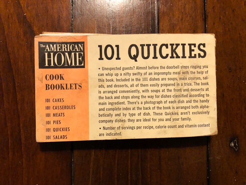 K&ouml;nnte beinhalten: Ein Vintage-Kochbuchcover mit dem Titel "101 Quickies" aus der Kochbuchreihe "The American Home". Das Cover ist orange, wei&szlig; und schwarz mit einer Liste von Kochb&uuml;chern: "101 Cakes", "101 Casseroles", "101 Meats", "101 Pies", "101 Quickies" und "101 Salads".